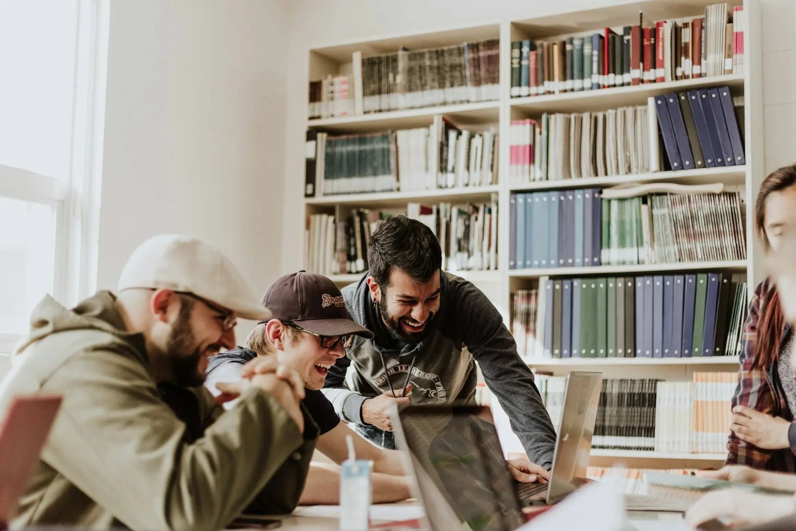 Students working together on a laptop in a library